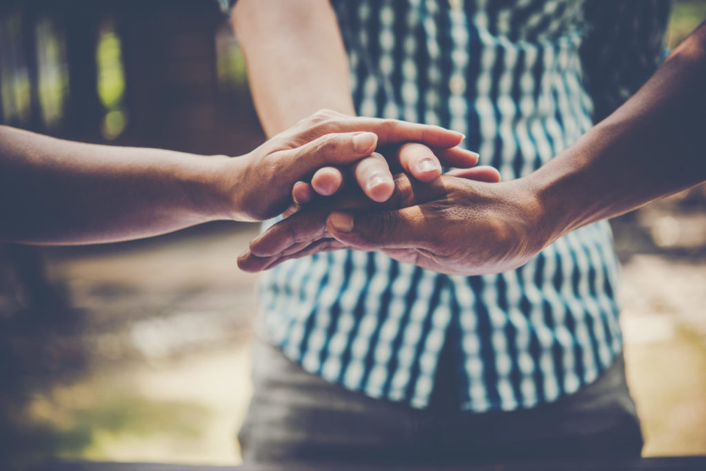 Two pairs of hands held together