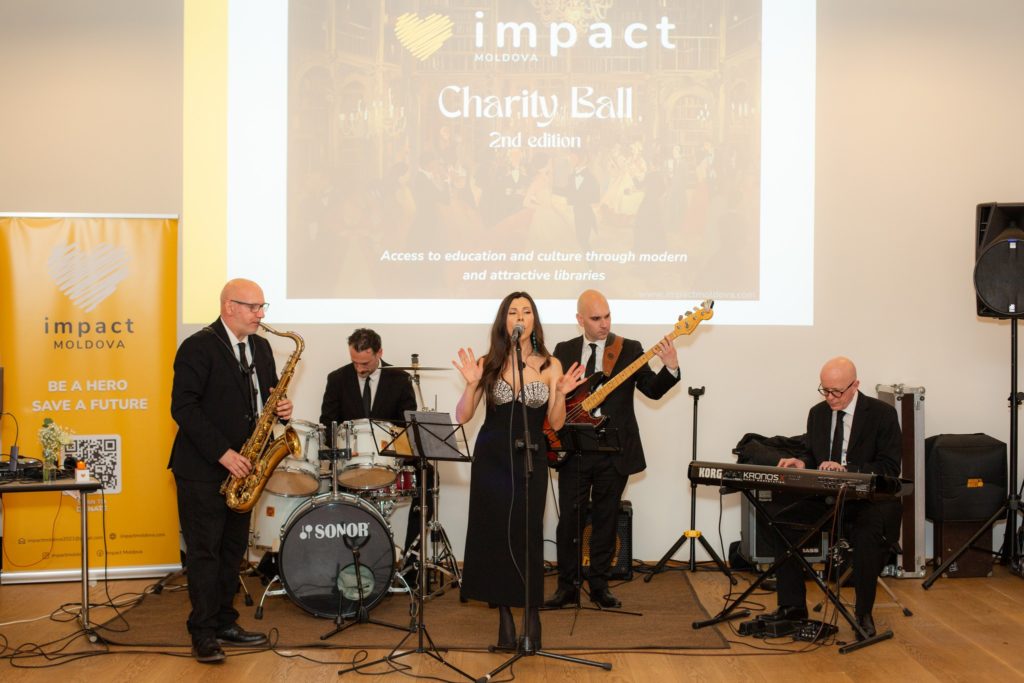 A live band playing in front of the impact projection screen